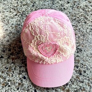 Ariat elastic back cap child’s pink with white lace and logo‎ on front .